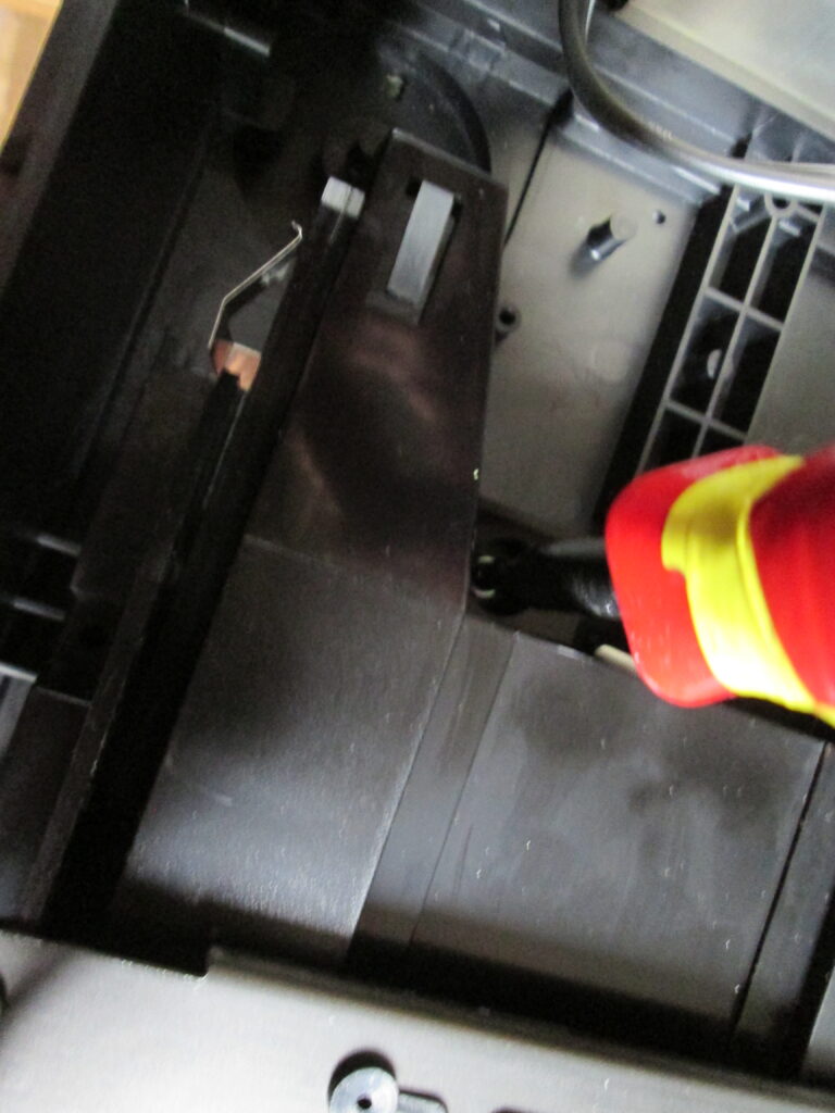 Unscrewing holding screws for the CD mechanism