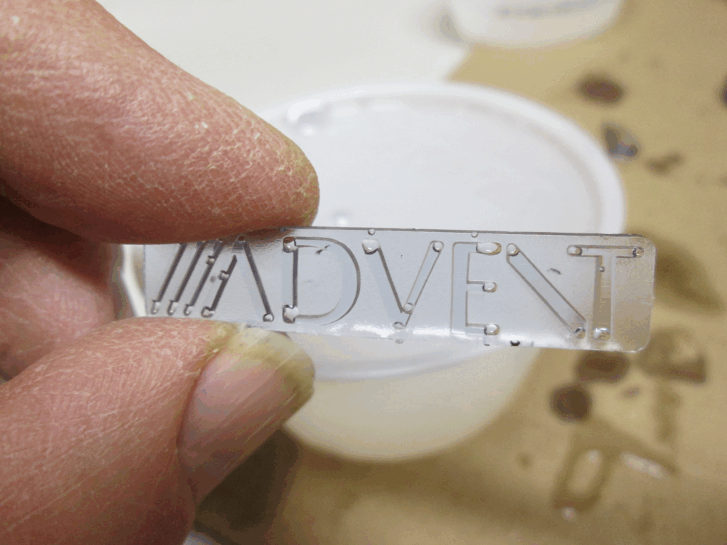 Reproduction of the Advent Graduate speaker logo badge pulled from the mold - notice that there are too many voids caused by bubbles